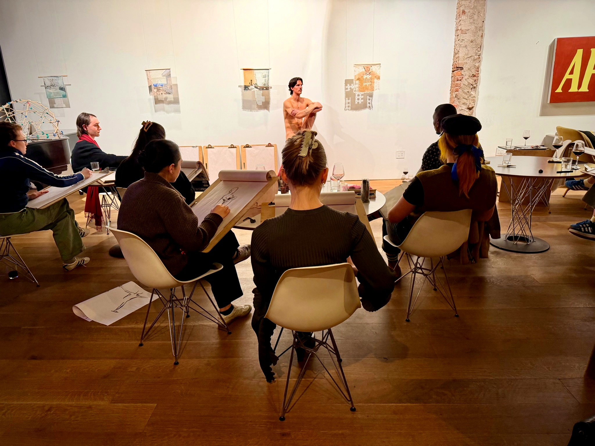 A figure drawing session in a bright gallery setting.